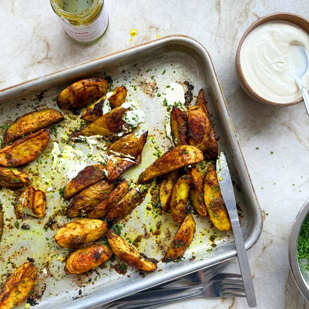Hawaij-spiced roast potatoes topped with soured cream and chives