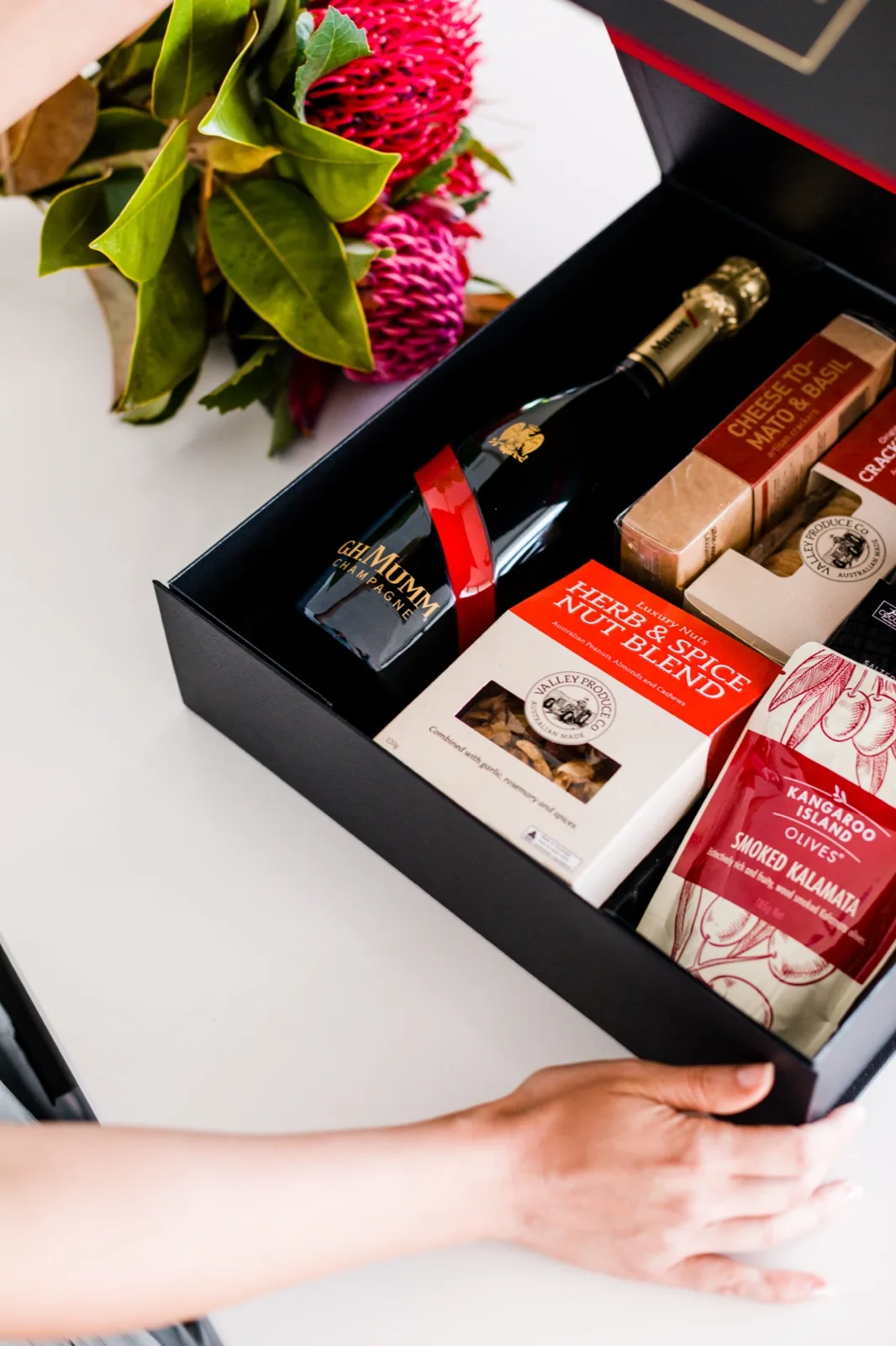 Open hamper from The Gourmet Pantry with G.H. Mumm champagne, artisan crackers, olives and spiced nuts