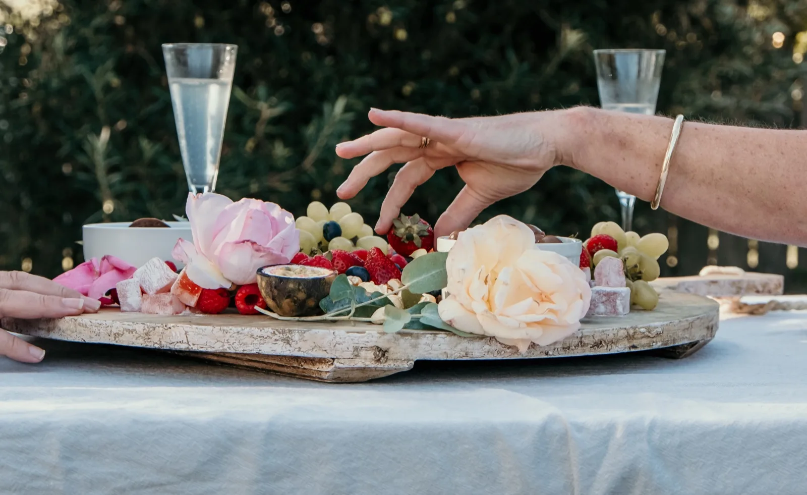 Grazing board of strawberries, grapes, passionfruit and Turkish delight shared at an outdoor table