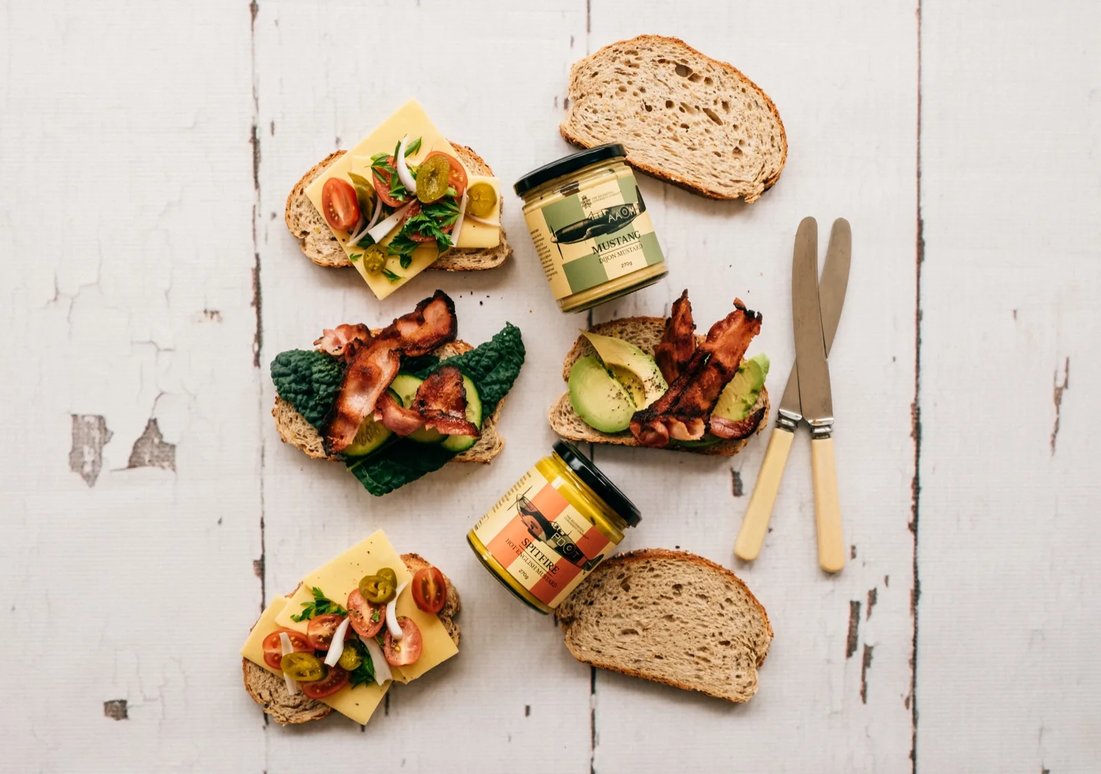 Mustang Dijon and Spitfire hot English mustard beside open sandwiches of bacon, cheese, avocado and sourdough