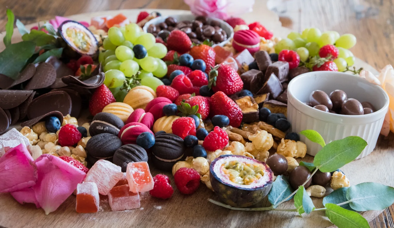 Dusted Turkish delight cubes with dark chocolate discs, chocolate coated nuts, berries and