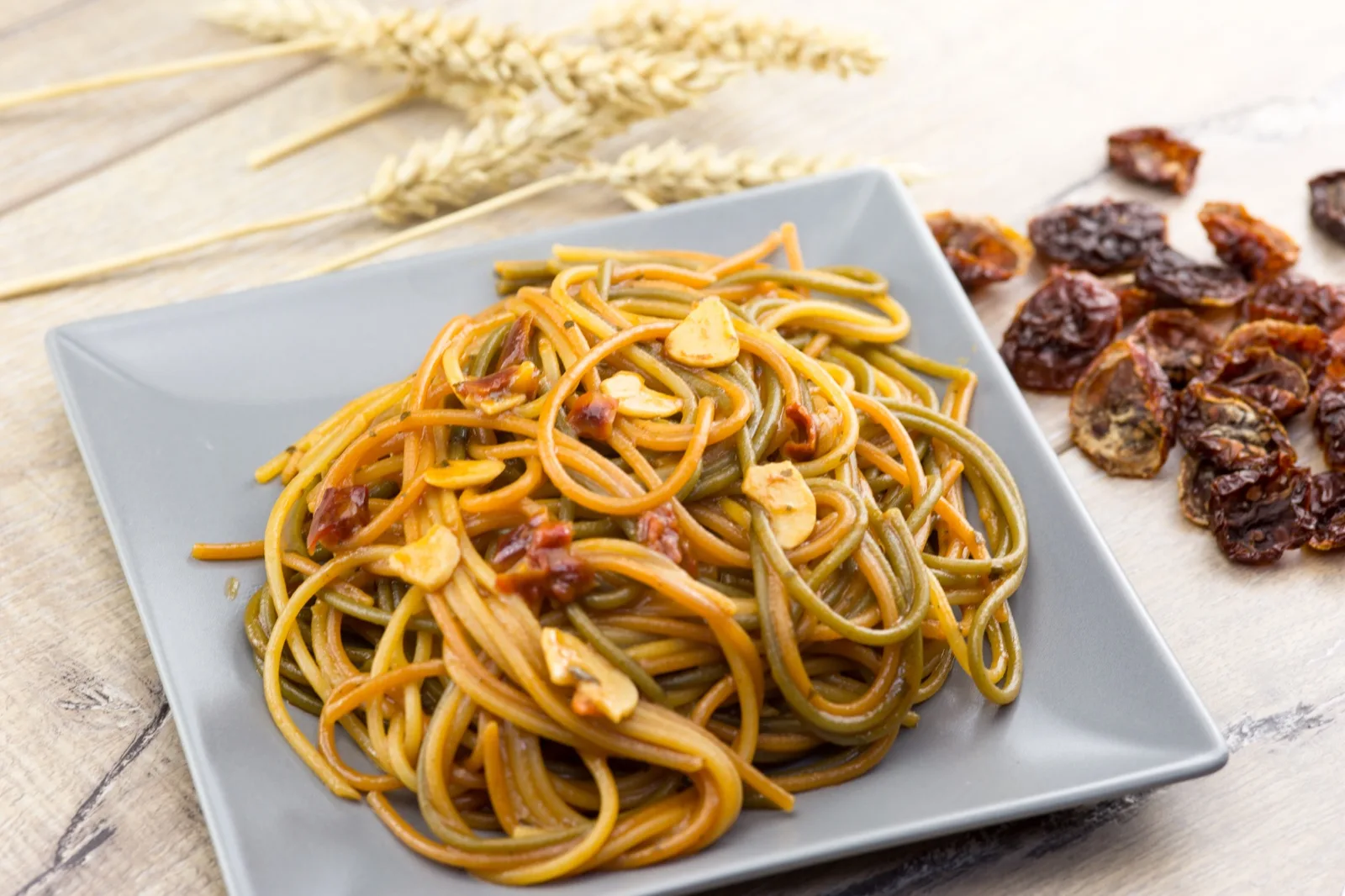 Tricolour pasta coated in a warm red sun dried tomato sauce with sliced garlic, no cheese 