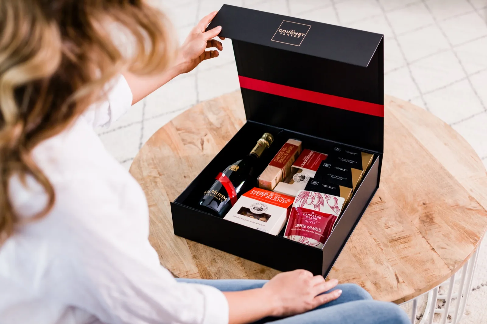 Open The Gourmet Pantry hamper packed with champagne, crackers, kalamata olives, nuts and chocolate