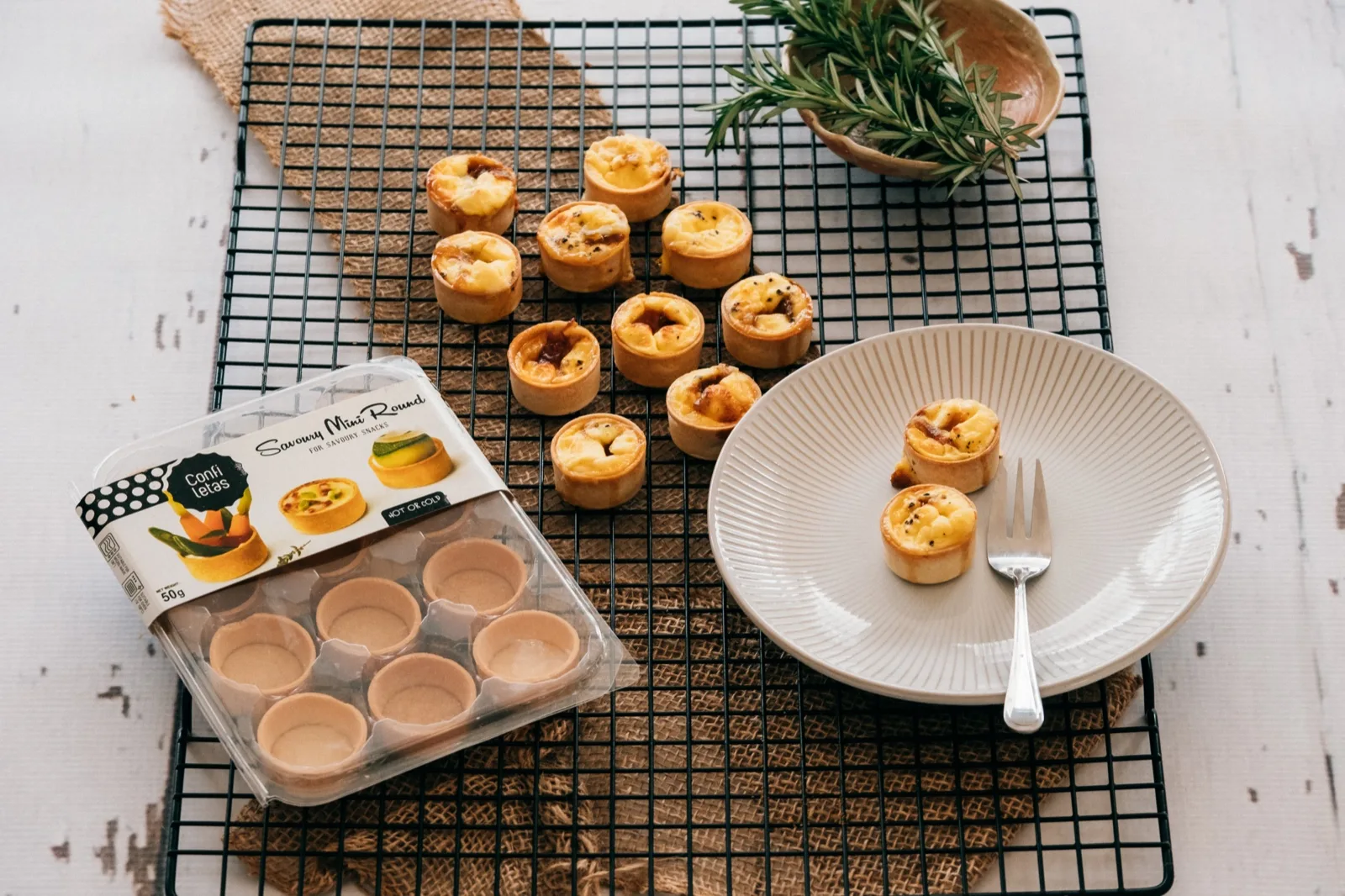 Confiletas savoury mini round pastry cases, baked and filled, cooling on a rack beside the